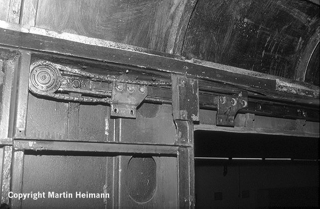 Der Kettenantrieb in Stellung „Tür offen“. Gut zu sehen sind die auf kugelgelagerten Schienen montierten Halterungen, an denen später die Türblätter verschraubt werden.